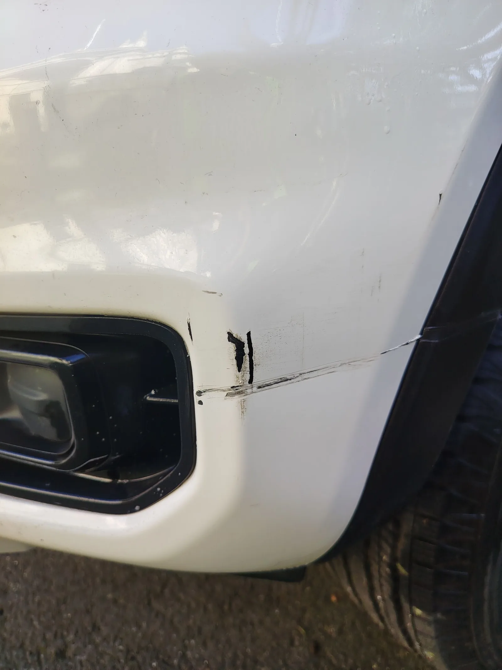 Car damage before repair - Deep bumper gouges on a ute repaired in an Oxford White colour match before professional scratch repair service